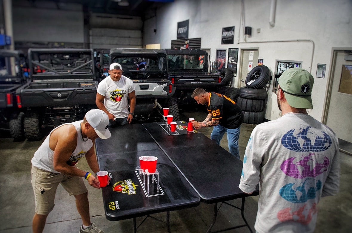 Shenanigans Pong - Fast-Paced Competitive Party Game Shoot, Bounce & Flip Cup Race Game. Includes 2 Silicone Mats, Cups & Balls  completive beer pong.